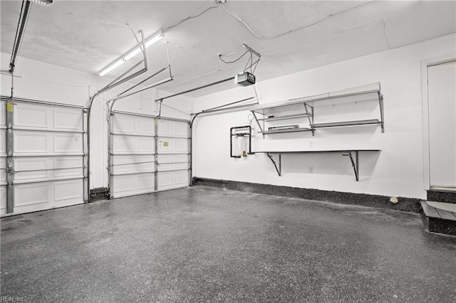 garage with baseboards and a garage door opener
