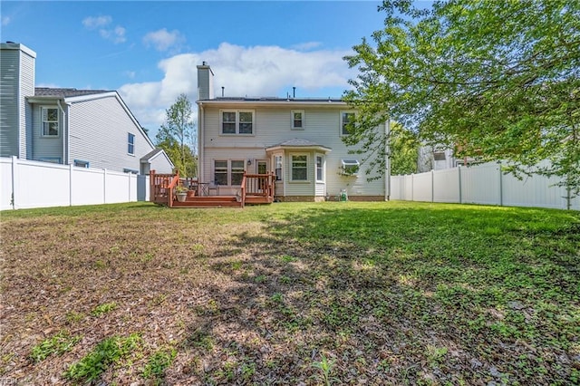 rear view of property featuring a yard, a fenced backyard, a deck, and a chimney