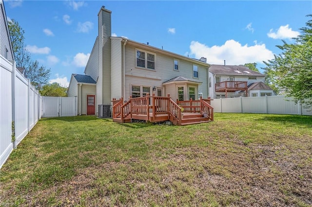 rear view of property with central AC unit, a deck, a lawn, a chimney, and a fenced backyard