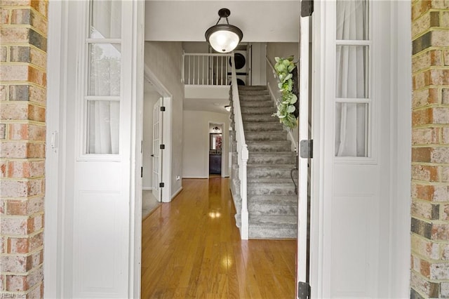 foyer featuring stairway, baseboards, and wood finished floors