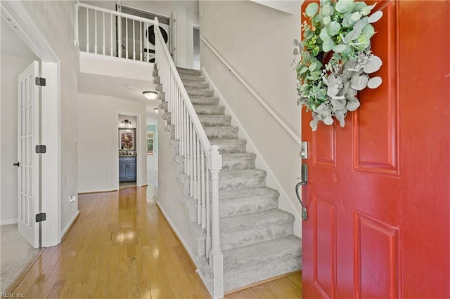 entryway featuring stairway, light wood-style flooring, and baseboards