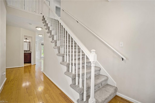stairway with baseboards and hardwood / wood-style flooring