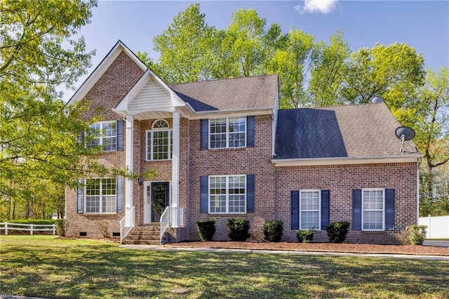 view of front of house featuring fence, a front lawn, and brick siding