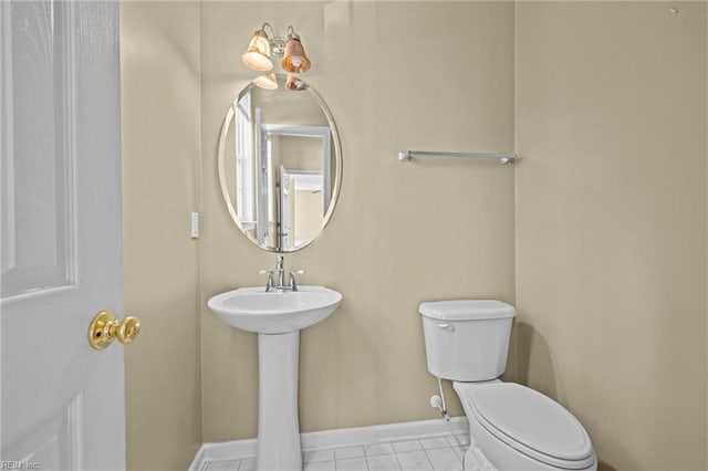 bathroom with toilet, a sink, and baseboards