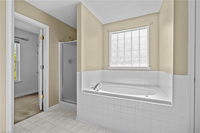 full bathroom featuring a shower stall, a garden tub, baseboards, and tile patterned flooring