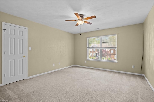 empty room with visible vents, ceiling fan, baseboards, and carpet