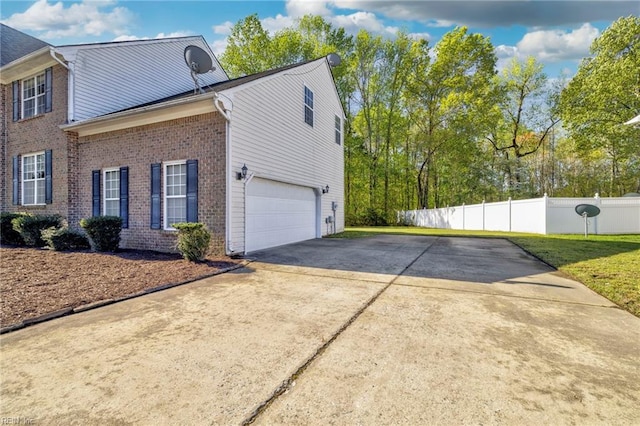 view of side of property with concrete driveway, brick siding, fence, and an attached garage