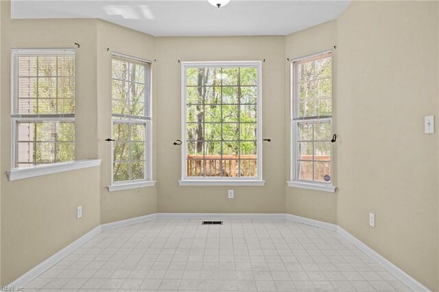 unfurnished room with visible vents and baseboards