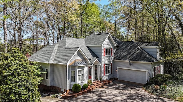 view of front of home with roof with shingles, driveway, and a garage