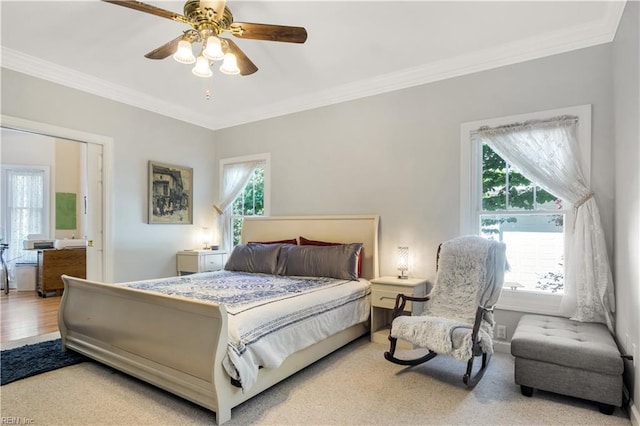 bedroom featuring ornamental molding, multiple windows, and a ceiling fan