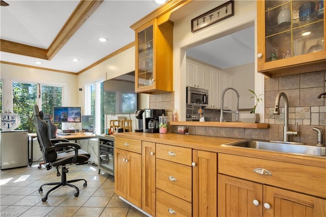 kitchen featuring light tile patterned floors, butcher block counters, tasteful backsplash, stainless steel microwave, and a sink