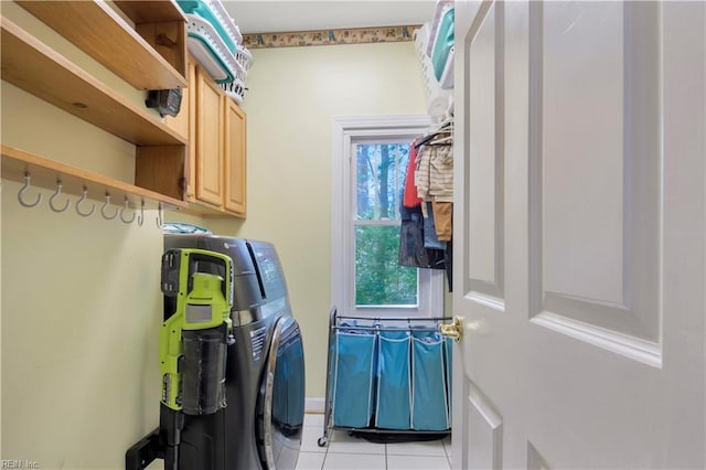 laundry room with cabinet space, light tile patterned floors, and separate washer and dryer