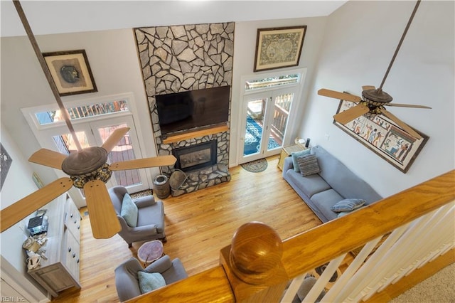 living room featuring wood finished floors, a fireplace, and a ceiling fan
