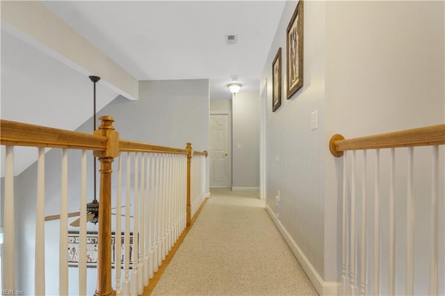 hallway with visible vents, baseboards, vaulted ceiling with beams, and carpet