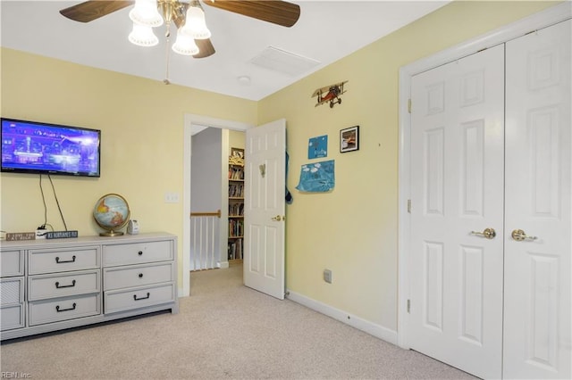 bedroom featuring light carpet, baseboards, and a ceiling fan