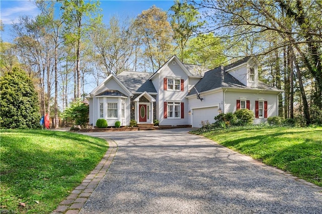 view of front of property featuring a front yard, an attached garage, and aphalt driveway