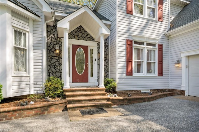 entrance to property with roof with shingles and stone siding