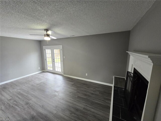 unfurnished living room with a fireplace, dark wood-style floors, french doors, and ceiling fan