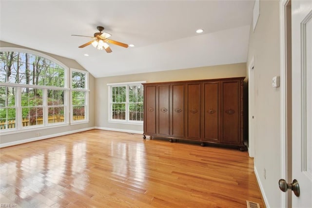 unfurnished bedroom featuring light wood-type flooring, visible vents, baseboards, and lofted ceiling