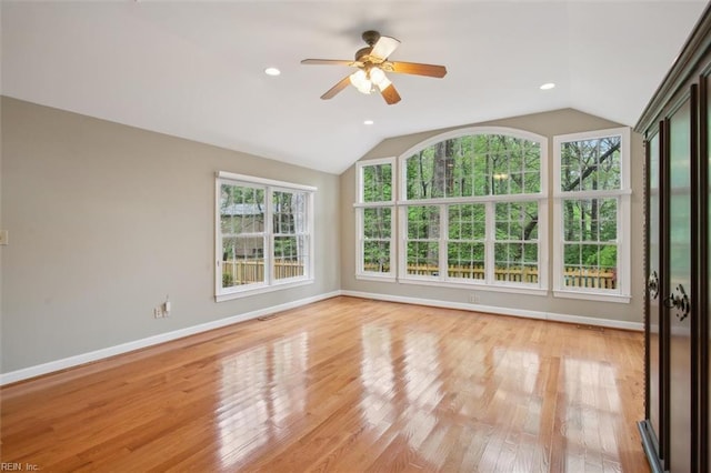 spare room with light wood-style floors, ceiling fan, baseboards, and lofted ceiling