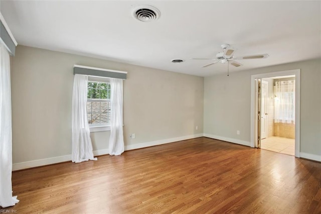 unfurnished bedroom with visible vents, baseboards, connected bathroom, and wood finished floors