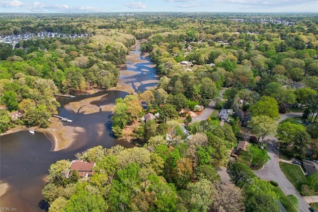 birds eye view of property with a water view and a wooded view
