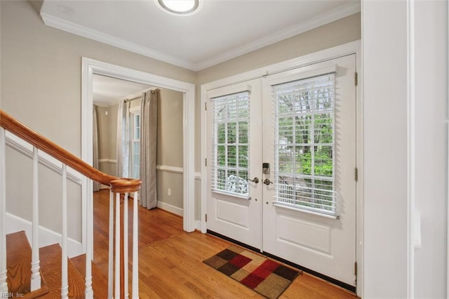 entrance foyer with stairway, light wood finished floors, french doors, and crown molding