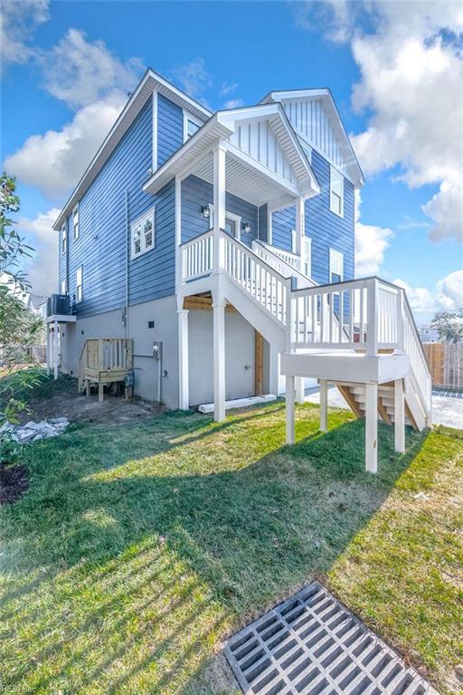 rear view of property with a yard and stairs