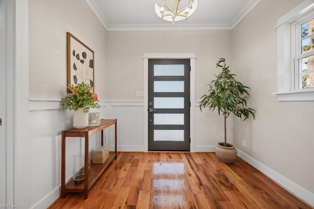 foyer entrance with wood finished floors and ornamental molding