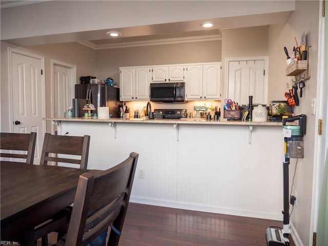 4734 Kempsville Greens Pkwy, Virginia Beach, VA 23462 - kitchen with a kitchen breakfast bar, white cabinetry, recessed lighting, stainless steel appliances, and dark wood-type flooring