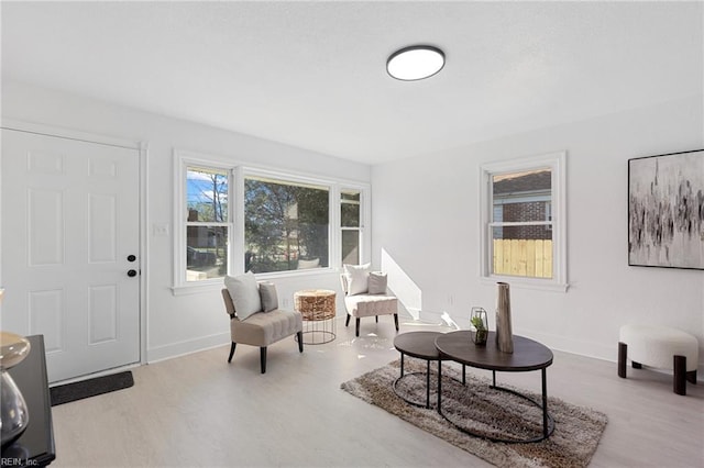 living area with baseboards and wood finished floors