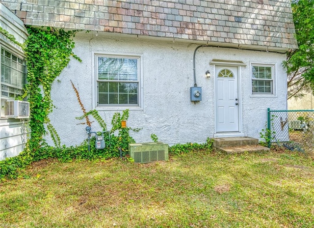 217 Hurley Ave, Newport News, VA 23601 - doorway to property featuring a yard, stucco siding, and mansard roof