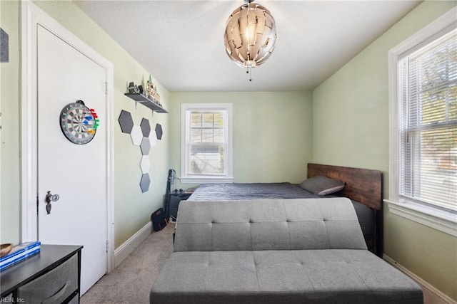 bedroom with baseboards and light carpet