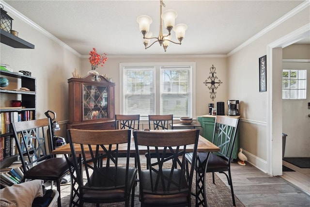 dining room featuring a chandelier, wood finished floors, ornamental molding, and plenty of natural light