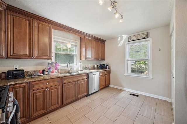 kitchen with baseboards, visible vents, brown cabinets, stainless steel appliances, and a sink