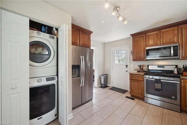kitchen with brown cabinetry, visible vents, stacked washer and clothes dryer, and appliances with stainless steel finishes