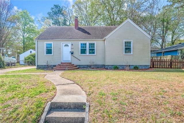 bungalow-style house with crawl space, a chimney, fence, a front lawn, and roof with shingles