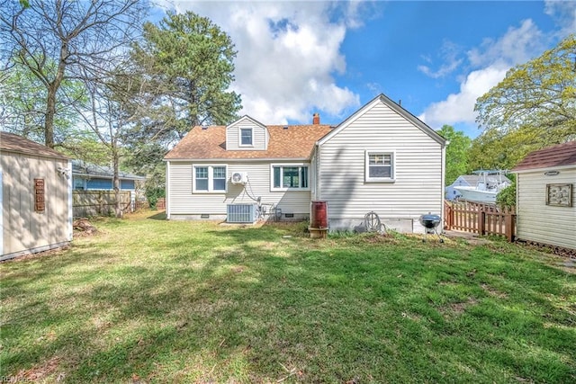 rear view of property with a lawn, a chimney, crawl space, fence, and roof with shingles