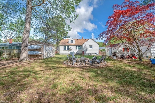 view of yard with an outdoor fire pit, a storage unit, fence, and an outdoor structure