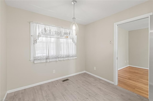 unfurnished dining area with visible vents, baseboards, and wood finished floors