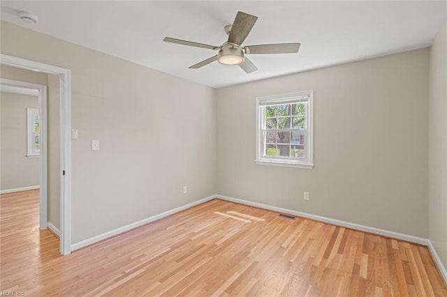 unfurnished room with light wood-style flooring, ceiling fan, baseboards, and visible vents