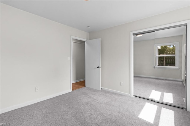 unfurnished bedroom featuring carpet, a closet, and baseboards
