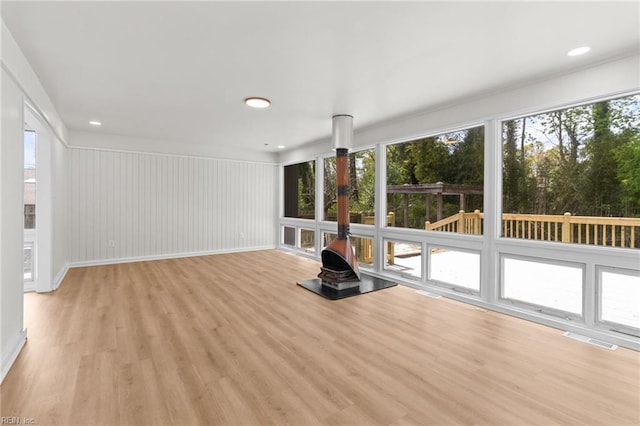 unfurnished sunroom featuring a wood stove and visible vents