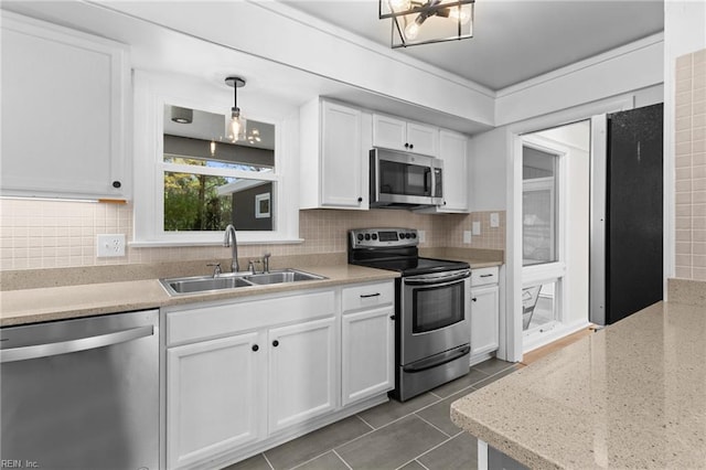kitchen featuring a sink, tasteful backsplash, white cabinets, and appliances with stainless steel finishes