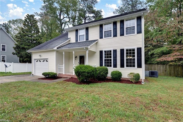 traditional-style house with central AC unit, driveway, fence, a garage, and a front yard