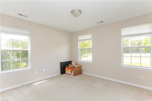 carpeted empty room with baseboards and visible vents
