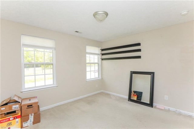 empty room with baseboards, visible vents, and carpet floors
