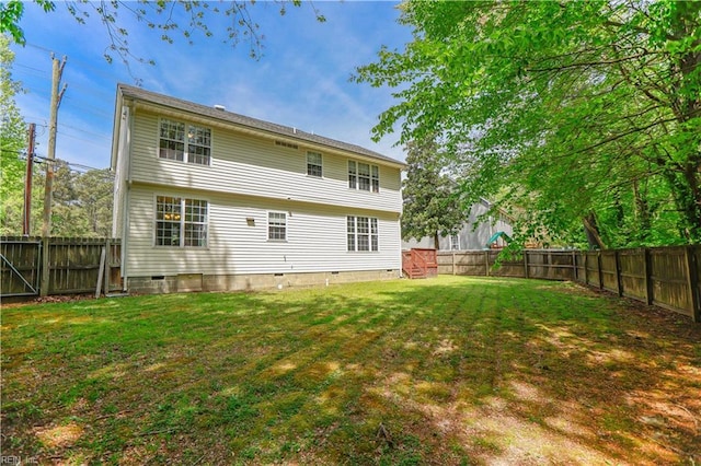 back of house featuring crawl space, a fenced backyard, and a yard