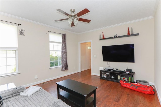 living room with wood finished floors, crown molding, baseboards, and a ceiling fan