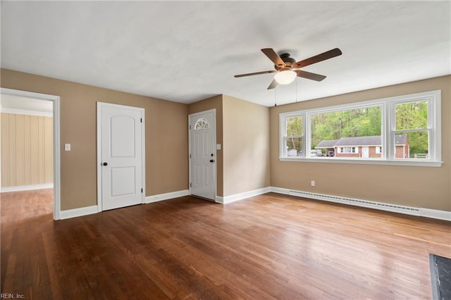 spare room with a baseboard radiator, ceiling fan, wood finished floors, and baseboards